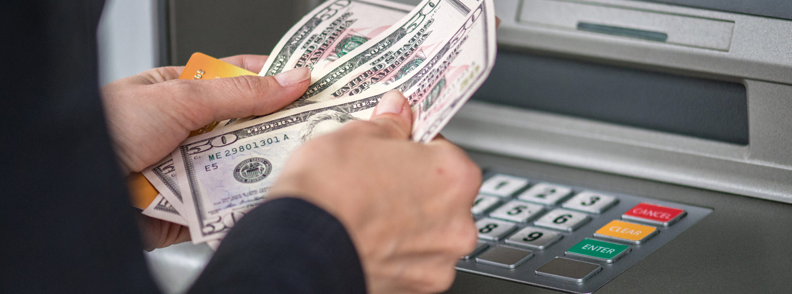 Person taking money out of an atm.
