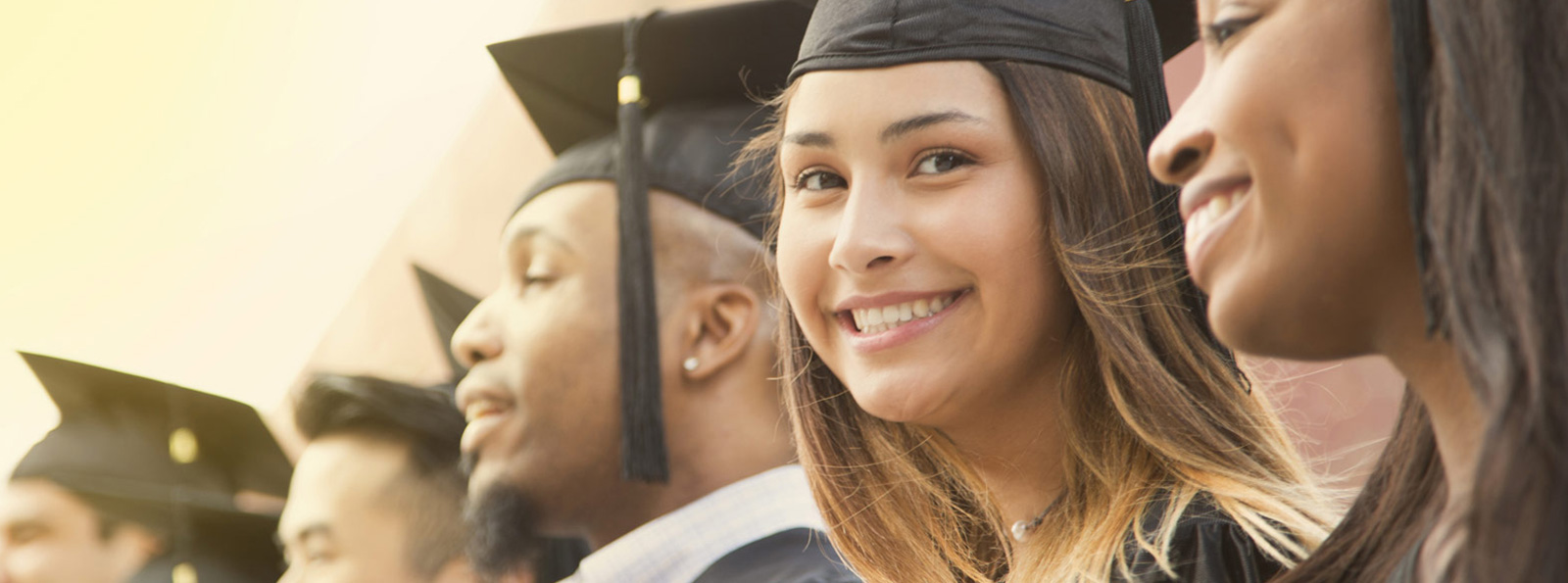 Graduates in a line smiling.