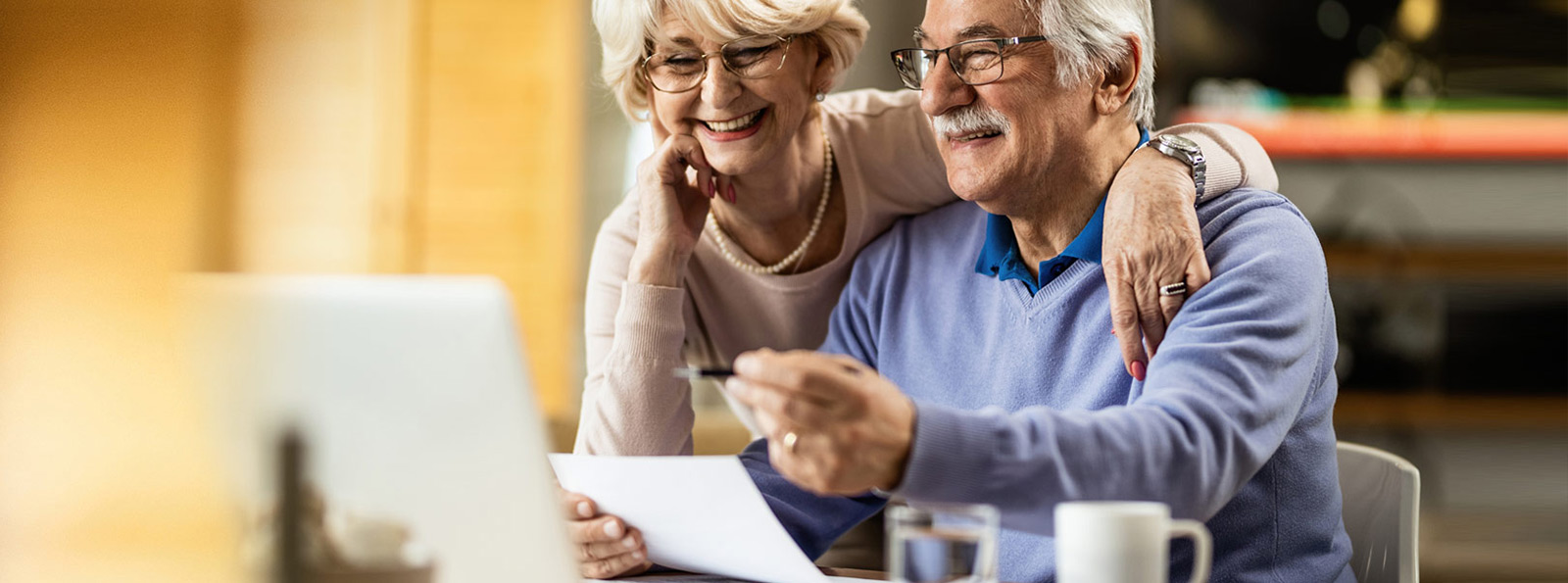Couple looking at their bills at a laptop.