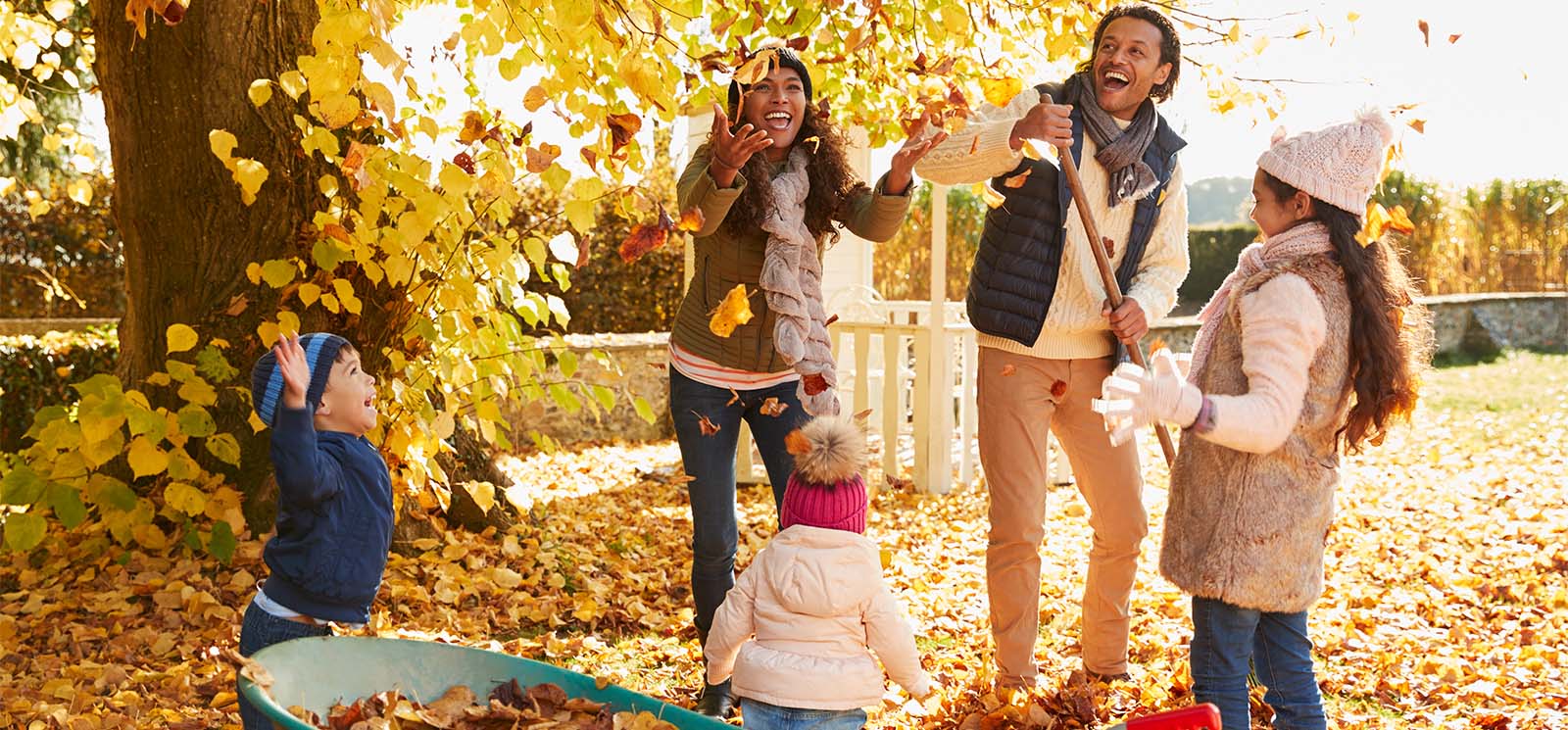 family playing in the fall leaves